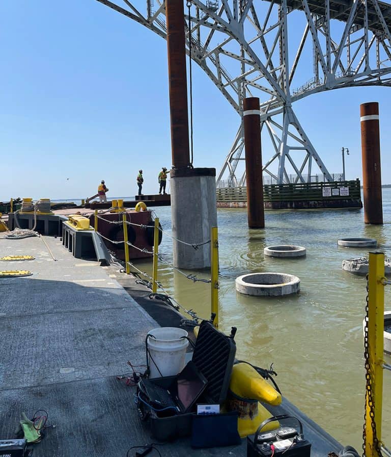 Environmental noise monitoring equipment deployed on a barge for a major bridge construction project over water.